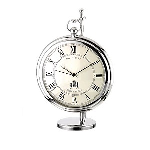 A STAINLESS STEEL STAND HOLDING A STAINLESS STEEL CLOCK. CLOCK IS MADE ROM STAINLESS STEEL CASE. GLASS LENS AND CLOCK MOVEMENT. MOVEMENT IS BATTERY OPERATED POWERED AND HAS NO ALARM.  CAN BE USED ON TABLE OR DESKTOP.CLOCK AND STAND ARE PACKED IN A PAPER AND CARDBOARD PRESENTATION BOX.  DIAMETER 120MM, THICKNESS 25MM. HEIGHT ON STAND 180MM. BATTERY LR44.