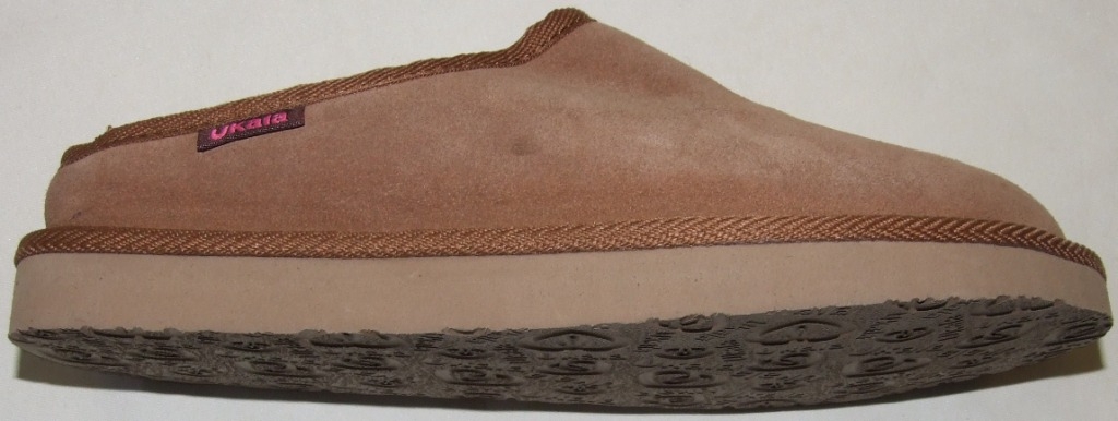 MULE STYLE SLIIPER WITH  UPPERS OF LEATHER (SUEDE) AND OUTER SOLES OF EVA WITH COMPANY NAME AND LOGO IMPRINTED INTO THE EVA. WITH A KNITTED PILE WOOL LINING. A LABEL SHOWING THE COMPANY NAME IS SEWN ONTO THE SIDE OF THE SLIPPER. IN-SOLE LENGTH EXCEEDS 24 CMS. CONSIGNED FROM CHINA. SAMPLE SEEN IS LIGHT BROWN.