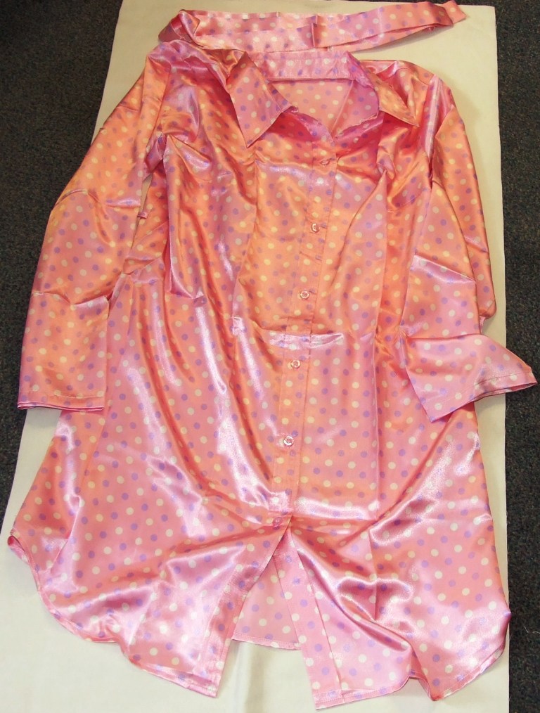 WOVEN LADIES NIGHTDRESS DESIGNED TO COVER THE BODY FROM THE SHOULDERS TO THE KNEE.  WITH COMPLETE OPENING FASTENED WITH BUTTONS RIGHT OVER LEFT. WITH LONG LOOSE FITTING SLEEVES HEMMED AT SLEEVE ENDS. WITH CURVED HEMLINE. WITH A COLLAR AND LAPELS. WITH V SHAPED NECKLINE. WITH DETACHABLE BELT. 100% POLYESTER.