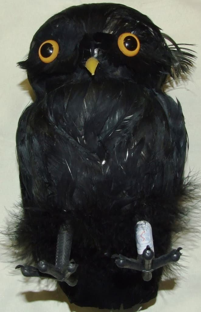 AN OWL. OF NATURAL FEATHERS. WITH POLYSTYRENE BODY AND PLASTIC EYES, BEAK AND FEET. MEASURES APPROX 22 CMS HIGH.
