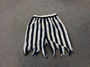 UNISEX WOVEN TROUSERS. PART OF A CHILDS FANCY DRESS PIRATE COSTUME. REACHING FROM WAIST TO BELOW THE KNEES.  ELASTICATED WAIST WITHOUT OPENING. JAGGED DESIGN AT LEG ENDS. OF POLYESTER.  PACKAGED FOR RETAIL SALE WITH A CONTRASTING SHIRT BLOUSE, WAISTCOAT, SASH BELT, SCARF AND EYE PATCH ALL CLASSIFIED SEPARATELY.