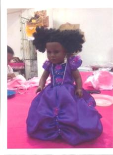 A DOLLS DRESS. OF POLYESTER. DECORATED WITH SEQUINS AND BEADS. MEASURES APPROX 32CMS LONG. DESIGNED TO BE WORN BY A DOLL OF 45CMS (H).  PACKAGED IN A PLASTIC BAG WITH SWING TAG.