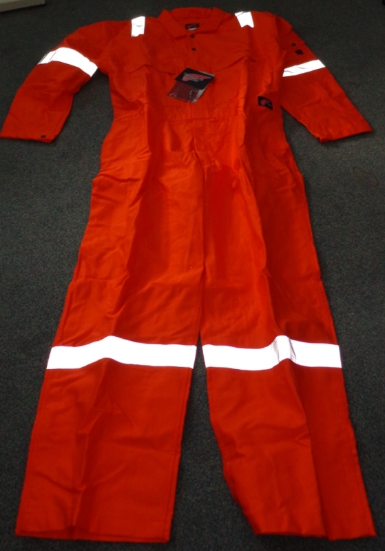 A WOVEN COVERALL OF 100% COTTON. IT IS A FLAME RESISTANT ARTICLE FOR USE IN WORKING ENVIRONMENTS WHERE EXPOSURE TO HIGH HEAT OR FLAMES MAY OCCUR.
IT HAS A CENTRAL ZIP FROM THE CHEST DOWN TO THE TOPS OF THE LEGS, COVERED WITH A LEFT OVER RIGHT FLAP AND WITH TWO PRESS STUDS ABOVE THE ZIP AT THE TOP. THERE ARE TWO BREAST POCKETS, EACH CLOSING WITH A ZIP, AND A SMALL POCKET ON THE LEFT ARM CLOSING WITH A PRESS STUD. THE REAR OF THE LOWER BACK HAS TWO POCKETS, EACH WITH A FLAP BUT NO CLOSING MECHANISM.
IT IS BRIGHT ORANGE IN COLOUR WITH SILVER REFLECTING STRIPS ON THE LEGS, ARMS AND SHOULDERS. ENCLOSED IN A PLASTIC BAG.