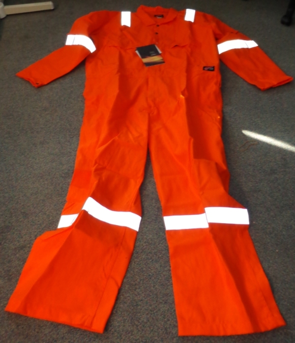 A WOVEN COVERALL OF 100% COTTON. IT IS A FLAME RESISTANT ARTICLE FOR USE IN WORKING ENVIRONMENTS WHERE EXPOSURE TO HIGH HEAT OR FLAMES MAY OCCUR.
IT HAS A CENTRAL ZIP FROM THE CHEST DOWN TO THE TOPS OF THE LEGS, COVERED WITH A LEFT OVER RIGHT FLAP AND WITH TWO PRESS STUDS ABOVE THE ZIP AT THE TOP. THERE ARE TWO BREAST POCKETS, EACH CLOSING WITH A ZIP, AND A SMALL POCKET ON THE LEFT ARM CLOSING WITH A PRESS STUD. THE REAR OF THE LOWER BACK HAS TWO POCKETS, EACH WITH A FLAP BUT NO CLOSING MECHANISM.
IT IS BRIGHT ORANGE IN COLOUR WITH SILVER REFLECTING STRIPS ON THE LEGS, ARMS AND SHOULDERS. ENCLOSED IN A PLASTIC BAG.