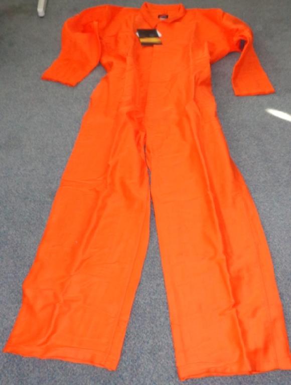 A WOVEN COVERALL OF 100% COTTON. IT IS A FLAME RESISTANT ARTICLE FOR USE IN WORKING ENVIRONMENTS WHERE EXPOSURE TO HIGH HEAT OR FLAMES MAY OCCUR.
IT HAS A CENTRAL OPENING FROM THE NECK DOWN TO THE TOPS OF THE LEGS WITH SEVEN BUTTONS, COVERED WITH A LEFT OVER RIGHT FLAP. THERE ARE TWO INTERNAL BREAST POCKETS WITH NO CLOSURE AT THE TOP. THE REAR OF THE LOWER BACK HAS TWO POCKETS, EACH WITH A FLAP CLOSING WITH VELCRO STRIPS. IT IS ELASTICATED AROUND THE PART JUST ABOVE THE TWO REAR POCKETS WITH AN INTERNAL DRAW PULL. IT IS BRIGHT ORANGE IN COLOUR.