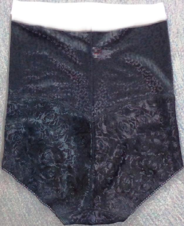 A KNITTED WAIST CLINCHER LADIES UNDERGARMENT INTENDED TO HUG THE WAIST AND HIPS. MADE OF POLYAMIDE AND ELASTANE. BLACK IN COLOUR, WITH A WHITE BAND ROUND THE TOP.