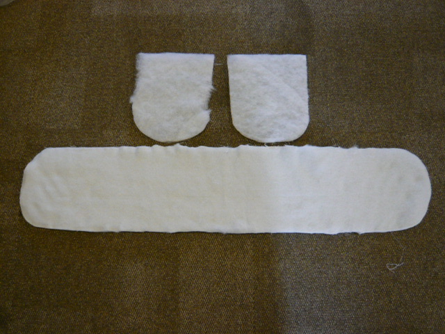 PRECISION CUT, SHAPED WADDING MADE OF 100% POLYESTER POLYFELT FIBRE WADDING 120 GSM.  THE WADDING IS USED AS A FILLING IN A TEXTILE DOUBLE OVEN GLOVE TO PROVIDE THERMAL PROTECTION CHARACTERISTIC.