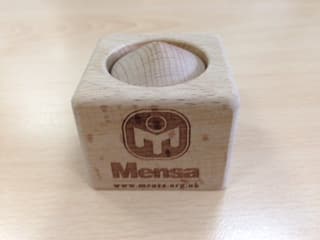 MENSA BLOCK OUT. WOODEN PUZZLE OF TWO PIECES. AIM TO SEPERATE THE TWO WITHOUT TOUCHING THEM. INTERNAL MEXCHANISM WHICH HOLDS THEM TOGETHER IS A SCREW ON ONE PIECE AND A MAGNET ON THE OTHER.