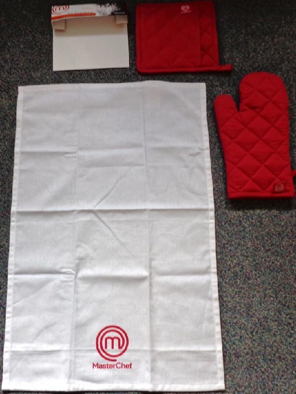 A WHITE TEA TOWEL MADE OF COTTON MEASURING 70 CMS BY 46 CMS. IT HAS A RED TRADE LOGO ON IT. PART OF A SET WHICH ALSO CONTAINS AN OVEN GLOVE AND A POT MITT. THESE TWO ITEMS HAVE BEEN CLASSIFIED SEPARATELY. THE ITEMS ARE IN A CARD HOLDER FOR RETAIL SALE.