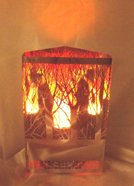 A POLISHED STEEL ORNAMENTAL FIREBOX DEPICTING A DETAILED FOREST SCENE. THE SCENE HAS BEEN ETCHED WITH ACID TO CREATE A HIGH LEVEL OF DETAIL ON THE FINISHED ARTICLE. THE SCENE IS LIT FROM WITHIN USING A SPECIAL LAMP THAT CREATES A NATURAL FLAME EFFECT - THE LIGHT FROM THE LAMP IS REFLECTED OUT BY THE HIGHLY POLISHED METAL SURFACE. THE ESSENTIAL CHARACTER IS GIVEN BY THE ORNAMENTAL METAL WORK AND THE LIGHT ONLY ENHANCES THE ORNAMENTAL APPEARANCE.
