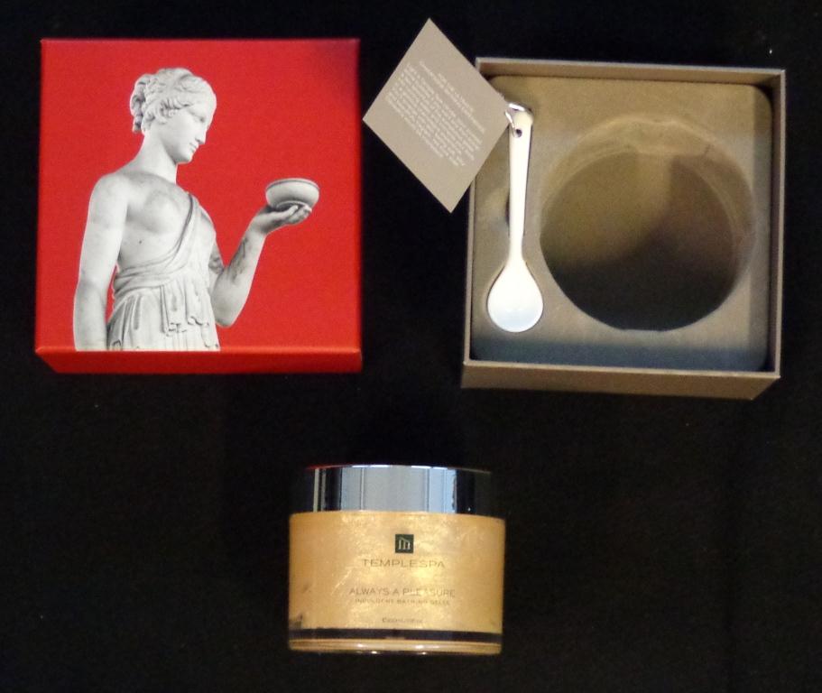 A 300ML JAR OF BATHING GELEE INFUSED WITH HONEY AND CHAMPAGNE. IT IS PART OF A SET WHICH ALSO INCLUDES A SMALL CERAMIC SPOON. THIS IS USED TO SCOOP SOME OF THE GELEE AND HOLD IT UNDER A RUNNING BATH TAP. THIS TURNS THE WATER INTO A MILKY COLOUR. THE JAR AND SPOON ARE CONTAINED IN A HARDBOARD BOX WITH A LID DEPICTING A ROMAN FIGURE.
