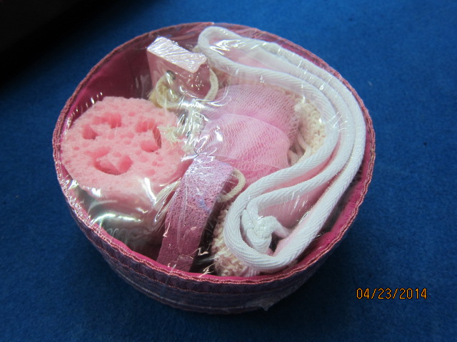 A BATH SET PRESENTED IN A  WOVEN WICKER BASKET. CONSISTS OF A BATH BELT MADE FROM POLY/COTTON, AN ARTIFICIAL BATH SPONGE, A BATH PUFF MADE FROM PU, A PUMICE STONE AND A NAIL BRUSH. CLASSIFIED AS LAST IN NUMERICAL ORDER. THE BRUSH.