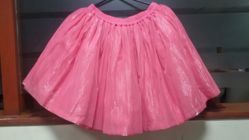 A GIRLS SKIRT CONSISTING OF 4 LAYERS. FIRST LAYER: 100% POLYESTER KNITTED NET FABRIC. SECOND LAYER: 86% COTTON, 14% METALLISED WOVEN FABRIC. THIRD LAYER: 100% POLYESTER KNITTED NET FABRIC. FOURTH LAYER 100% POLYESTER WOVEN FABRIC. COLOUR: PINK.