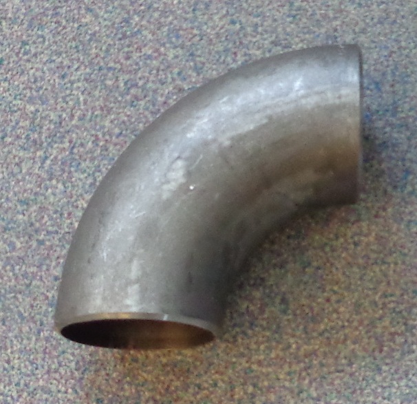 THE PRODUCT IS A CARBON STEEL WELDING ELBOW. THE ITEM IS NOT CAST AND HAS AN INNER DIAMETER OF 4 INCHES AND AN OUTER DIAMETER OF 4.5 INCHES. THE ENDS OF THE ELBOW ARE CHAMFERED AND ON THE TOP OF ONE OF THE SIDES IS A PRODUCT CODE WHICH HAS BEEN STAMPED INTO THE STEEL.