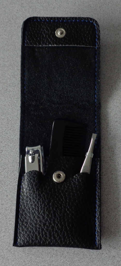 MENS MINI GROOMING SET. CONTAINS METAL NAIL CLIPPERS, METAL TWEEZERS AND A BLACK PLASTIC COMB. PACKED TOGETHER IN A BLACK PVC POUCH WITH PRESS BUTTON FASTENING. THE INNER POCKET SECTION OF THE POUCH HAS SLOTS TO HOLD THE 3 IMPLEMENTS IN PLACE. POUCH MEASURES 4 1/4 INCHES BY 2 1/2 INCHES.