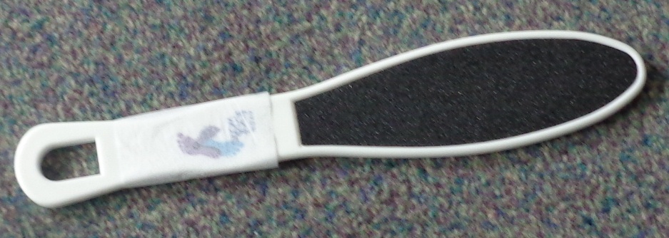 PADDLE FOOT FILE. FILE HAS A POLYPROPYLENE HANDLE WITH EMERY PAPER ON TWO SIDES. THE GRANULES ARE SAND ON PAPER. USED TO SMOOTH THE SOLES OF YOUR FEET AND FOR FILING TOE NAILS. SIZE 24CM LONG X 0.6CM THICK.