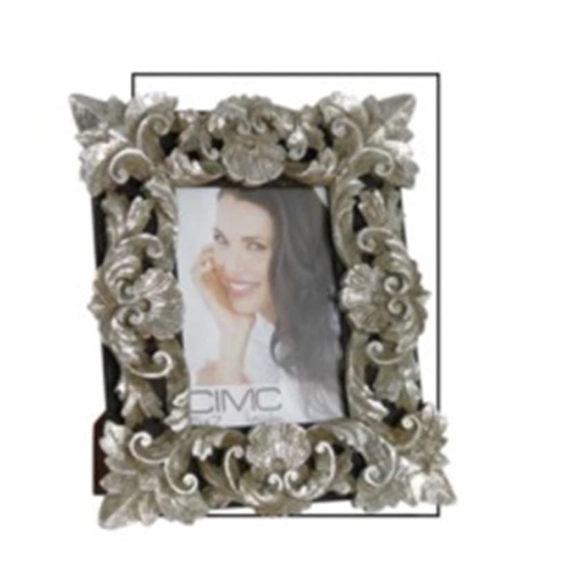 A PHOTO FRAME MADE OF WOOD (MDF), AND STAINED DARK BROWN. THE FRONT OF THE FRAME HAS A FLORAL DESIGN MADE OF ARTIFICIAL STONE (POLYRESIN) STUCK TO IT. THE DESIGN GOES AROUND THE GLASS WINDOW AND COVERS THE FRAME. THE GLASS WINDOW HOLDS A 6X4 INCH PICTURE. POLYRESIN IS MADE OF 55% STONE AND 45% RESIN