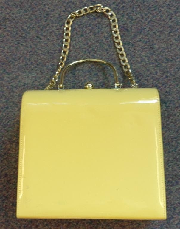 PATENT POLYURETHANE HANDBAG. MADE FROM PU SHEETING. WITH METAL HANDLE  AND SHOULDER STRAP. CLASP FASTENING AND TEXTILE INNER LINING . YELLOW IN COLOUR.