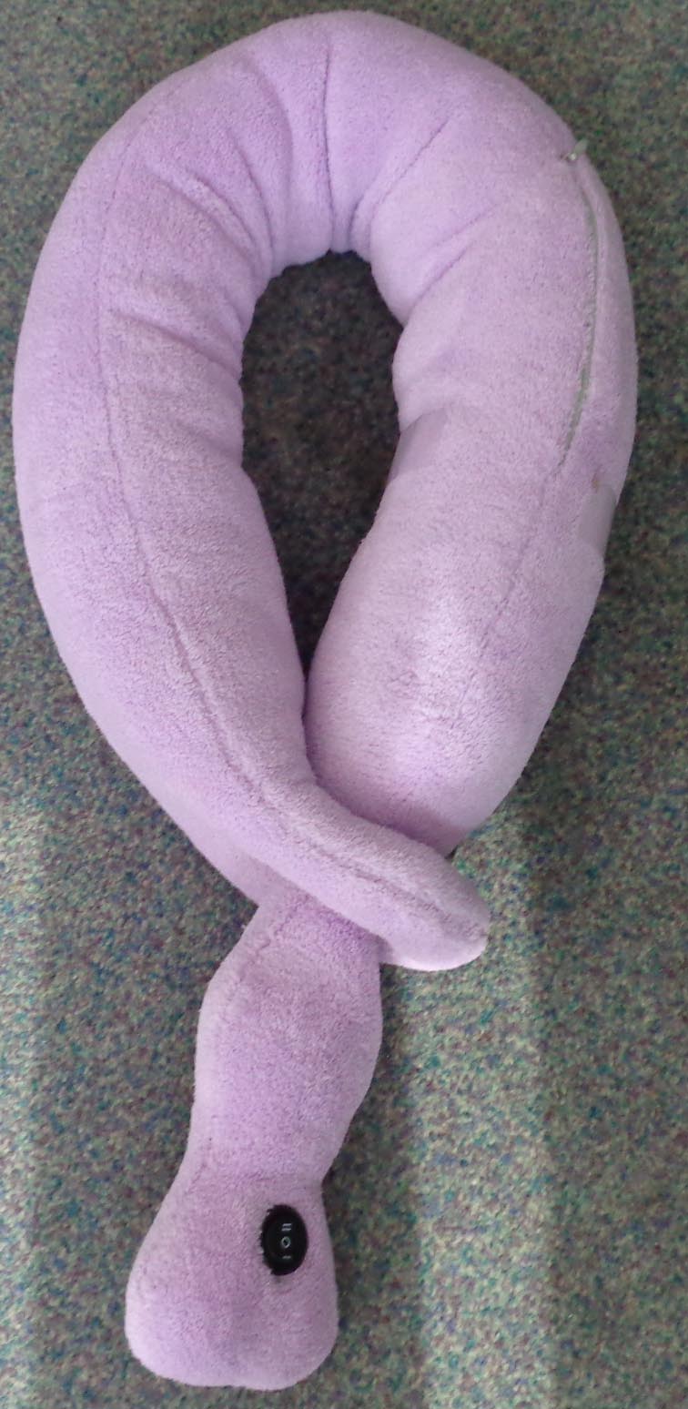 VIBRATING NECK PILLOW. A STUFFED POLYESTER PILLOW THAT IS DESIGNED TO BE WRAPPED AROUND THE NECK. THE PRODUCT CONTAINS A BATTERY OPERATED VIBRATING MECHANISM THAT CAN BE TURNED ON AND OFF BY PUSHING A BUTTON.