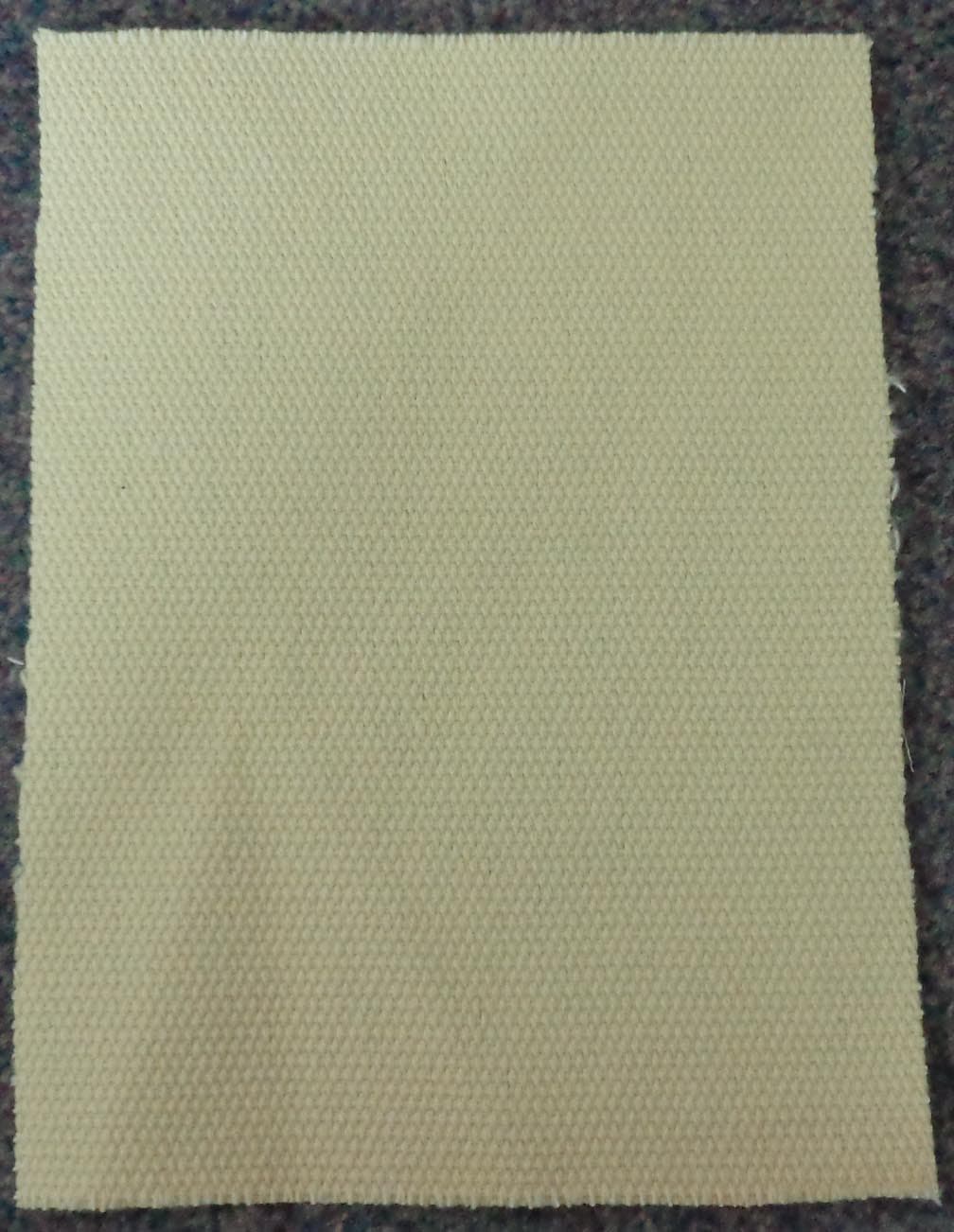 WOVEN FABRIC OF FIBREGLASS, STAPLE FIBRE (META-ARAMID AND PARA ARAMID), FLANELETTE AND A POLYAMIDE WEB ADHESIVE. NOT WOVEN FROM ROVINGS. IN 50 METRE ROLLS, 100 CENTIMETRES WIDE. THE FABRIC HAS THE FIBRE GLASS AS A CORE AND THE STAPLE FIBRE AS A SHEATH. THE FLANALETTE IS LAMINATED TO ONE SURFACE OF THE FABRIC. WEIGHT IS 820 GRAMMES PER SQUARE METRE. USED TO MAKE PROTECTIVE CLOTHING, SUCH AS GLOVES.