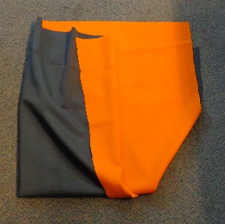 A KNITTED FABRIC OF 78% POLYAMIDE AND 22% ELASTANE. HAS A WIDTH OF 145 CENTIMETRES, AND A WEIGHT OF 395 GRAMMES PER SQUARE METRE. BLACK ON ONE SIDE AND ORANGE ON THE OTHER.