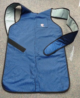 AN APRON FOR USE BY HEALTHCARE WORKERS WHEN WORKING IN OR AROUND RADIATION. IT COVERS THE FRONT OF THE BODY AND PART OF THE LEGS. TWO WIDE STRAPS GO OVER THE SHOULDERS, CROSS OVER ON THE BACK AND ARE ATTACHED BY VELCRO TO THE SIDES OF THE APRON NEAR THE HIPS. HAS A POCKET ON THE LEFT AT THE TOP. THE OUTER SURFACE IS MADE OF NYLON. BENEATH THIS LIES BARIUM SULPHATE AND BISMUTH OXIDE IN A POLYMER MATRIX COMPOSITE. THE INNER LINING IS MADE OF NYLON. CONTAINED IN A SEE THROUGH BAG, WHICH IS THEN PLACED IN A CORRUGATED BOX. CAN BE USED BY MEN OR WOMEN.