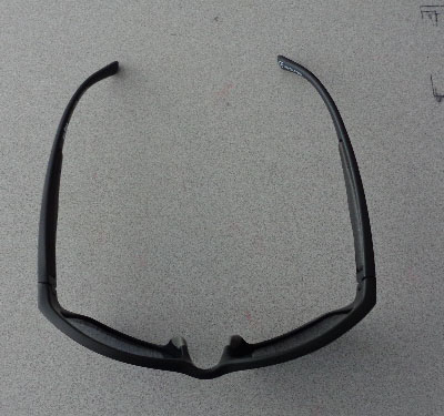 A PAIR OF BLACK SUNGLASSES WITH 100% GLARE-FREE POLARISED LENSES. THE SUNGLASSES HAVE LENSES OF PLASTICS THAT HAVE NOT BEEN OPTICALLY WORKED.