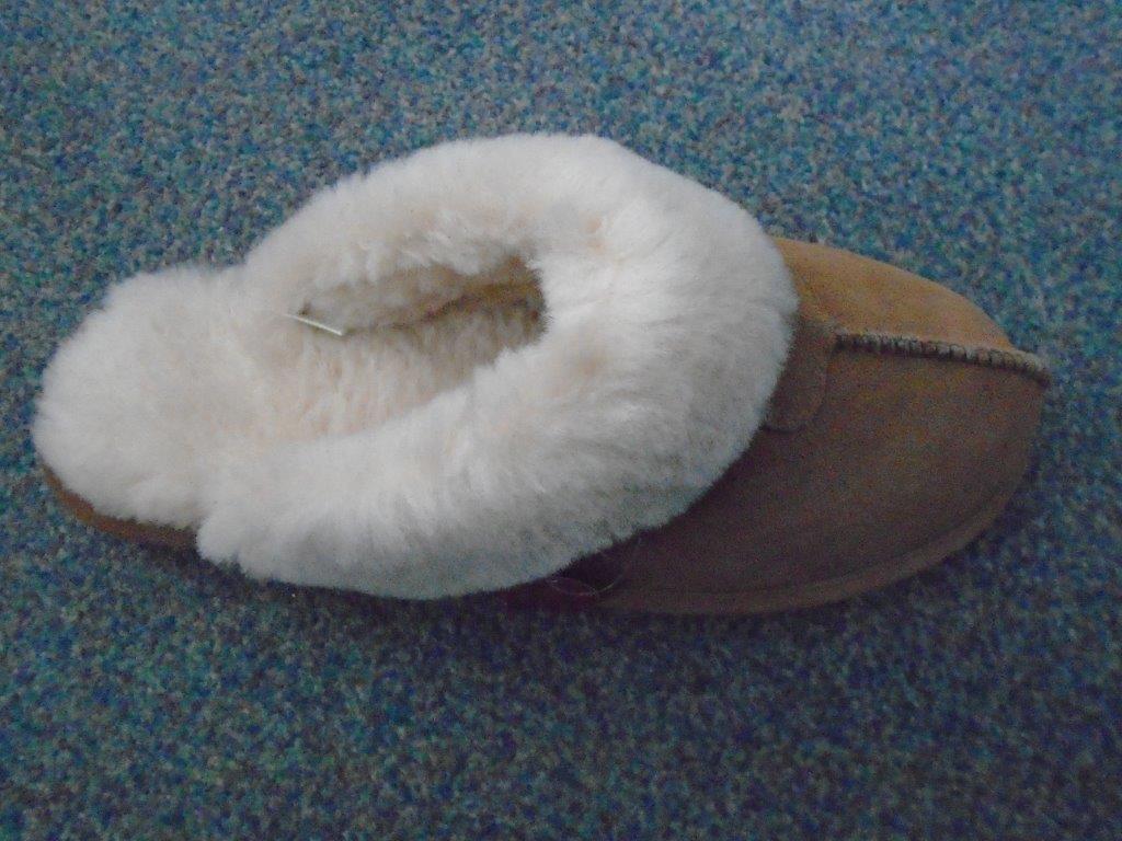 LADIES SLIP ON MULE SLIPPER WITH UPPERS OF SUEDE AND OUTER SOLES OF PLASTIC, WITH A LAMBS WOOL LINING. NOT COVERING THE ANKLE. CHESTNUT IN COLOUR, WITH A 2 CM FLAT HEEL.