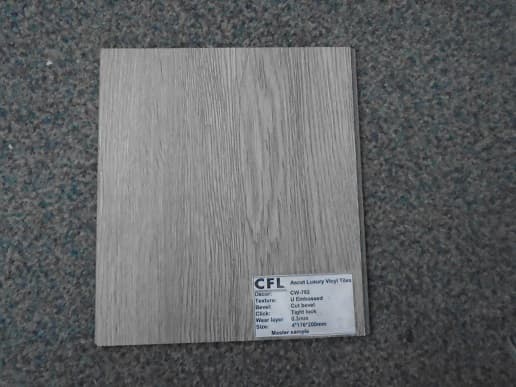 A FLOOR TILE COMPOSED OF CALCIUM CARBONATE (LIMESTONE), PVC PLASTIC, STABILIZER AND PIGMENTS. IT MEASURES 20 X 18 CMS, AND HAS A WOOD-LIKE APPEARANCE ON THE TOP.