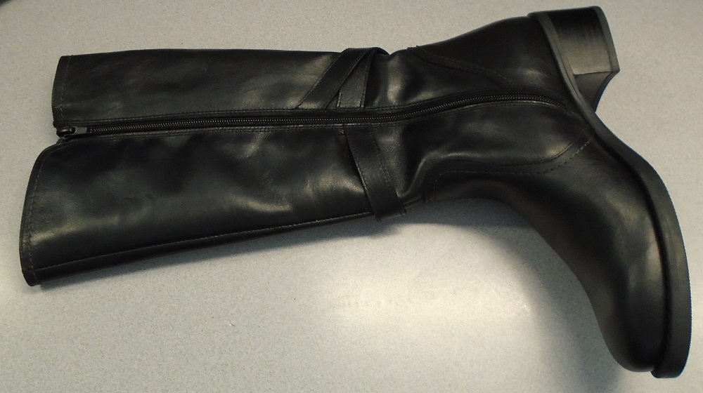 LADIES LONG BOOTS WITH ZIP FASTENING.  UPPERS OF LEATHER.  BLACK IN COLOUR.  THE BOOTS COVER THE ANKLE AND THE CALF.  TWO STRAP DECORATION   WITH METAL STUD ON ONE STRAP AND METAL RING ON OTHER STRAP.  THE DECORATIVE STRAPS ARE ABOVE THE ANKLE AND THE STRAPS CROSS OVER AT THE BACK OF THE BOOTS.  FRONT EDGE OF THE BOOT IS 1 CM HIGHER THAN THE BACK PART.  OUTER SOLES OF RUBBER.  HEEL HEIGHT 4 CMS.  FULL LENGTH ZIP.  LINING OF OTHER MATERIALS (TEXTILE).  INSOLES OF A LENGTH MORE THAN 24 CMS.