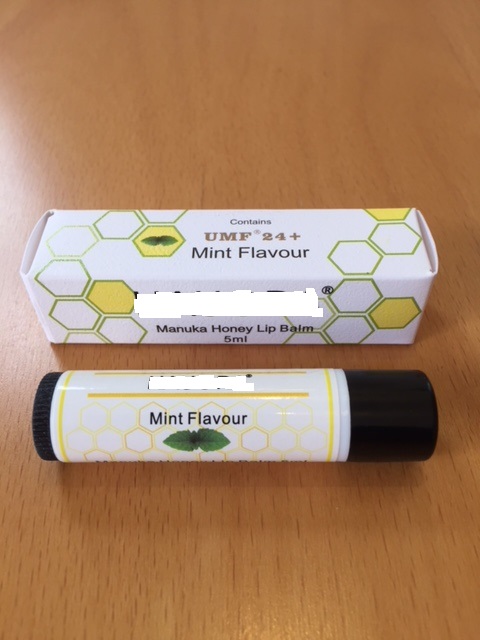 MINT FLAVOURED LIP BALM CONTAINING SWEET ALMOND OIL, BEESWAX, EVENING PRIMROSE OIL, CERESIN WAX, MACADEMIA OIL, JOJOBA OIL, MANUKA HONEY, FLAVOUR, VITAMIN E, SHEA BUTTER, AND VITAMIN A. CONTAINED IN A 5 ML TUBE WHICH IS IN A CARDBOARD BOX.