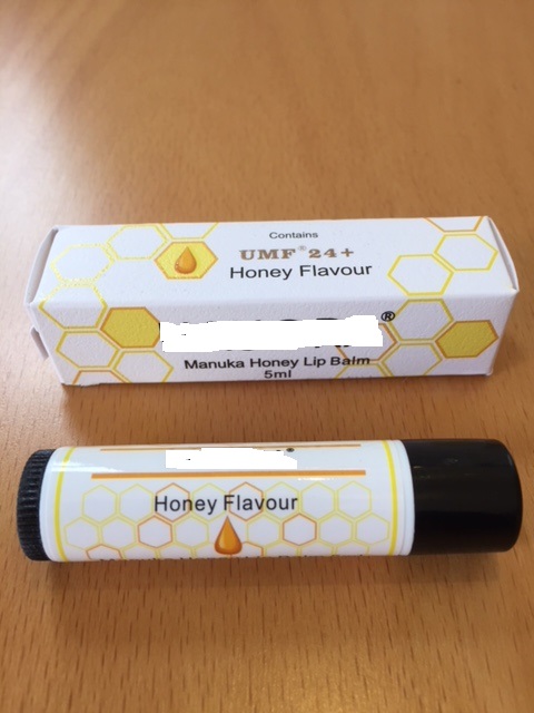 MANUKA HONEY LIP BALM CONTAINING SWEET ALMOND OIL, BEESWAX, EVENING PRIMROSE OIL, CERESIN WAX, MACADEMIA OIL, JOJOBA OIL, MANUKA HONEY, FLAVOUR, VITAMIN E, SHEA BUTTER, AND VITAMIN A. CONTAINED IN A 5 ML TUBE WHICH IS IN A CARDBOARD BOX.