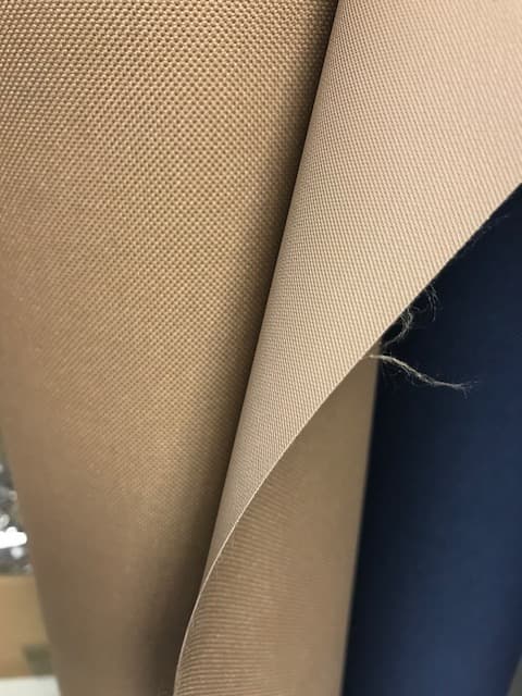 A WOVEN POLYESTER TEXTILE.  VISIBLY COATED ON ONE SIDE WITH AN EMBOSSED NON CELLULAR PU PLASTIC COATING. ON A ROLL. SAMPLE SEEN GREEN IN COLOUR