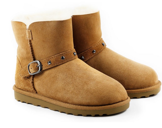 CHILDREN'S SHEARLING BOOT WITH BUCKLE. IT COVERS THE ANKLE BUT NOT THE CALF. THE UPPER IS MADE OF SHEEPSKIN, WITH A COW SUEDE HEEL. THE OUTER SOLE IS MADE OF POLYURETHANE. HAS A STRAP GOING OVER THE FOOT WITH A BUCKLE TO ONE SIDE.