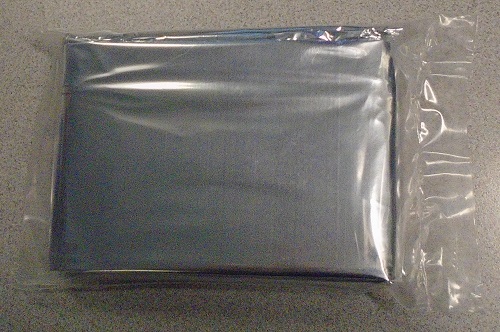 LIGHTWEIGHT EMERGENCY FOIL BLANKET.  USED FOR HEAT RETENTION.  THE FOIL BLANKET IS MADE FROM ONE LAYER OF P.E.T (POLYETHYLENE TEREPHTHALATE) AND ONE LAYER OF ALUMINIUM.  THE TOTAL THICKNESS OF 2 PLY IS 0.012 MM (PET IS 0.01 MM AND ALUMINIUM IS 0.002 MM).  METALLIC SILVER IN COLOUR.  THE FOIL BLANKET MEASURES APPROXIMATELY 140 CMS X 210 CMS.  THE BLANKET IS WATERPROOF AND RE-USABLE.  PACKAGED IN SEALED SMALL PLASTIC BAG MEASURING 14 CMS X 9 CMS WITH FLYER SHOWING COMPANY NAME, COMPANY LOGO AND THE USES OF THE THERMAL BLANKET.