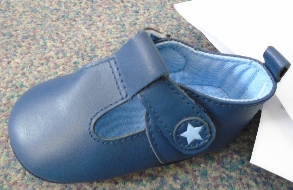 BABIES SHOE WITH LEATHER UPPER NOT COVERING THE ANKLE.THE SOLE IS MADE OF LEATHER. THERE IS A  VELCRO FASTENNG STRAP ACROSS THE FOREFOOT WITH A DECORATIVE STAR. THERE IS A LIGHT BLUE TEXTILE LINING. LESS THAN 24CM