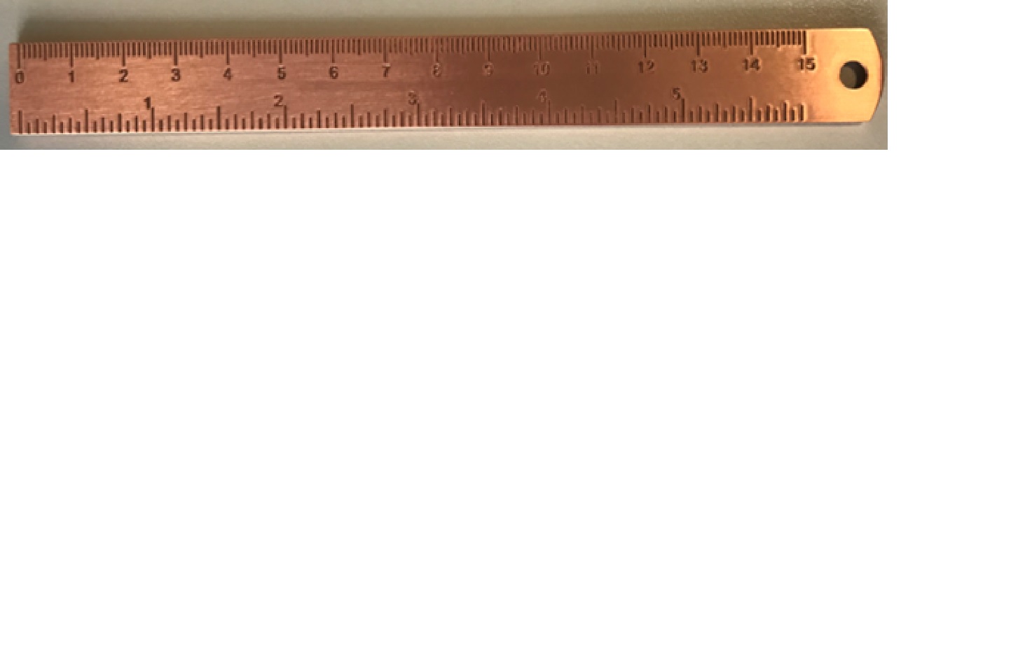 A COPPER RULER APPROX 16CM IN LENGTH, FOR MEASURING AND DRAWING STRAIGHT LINES. ALONG TOP EDGE MARKINGS FOR 0 - 15CM. THE BOTTOM EDGE HAS MARKINGS FROM 0 - 6 INCHES. AT ONE END OF THE RULER THERE IS A HOLE TO ALLOW ITEM TO BE HUNG ON A WALL OR OTHER MOUNTING.