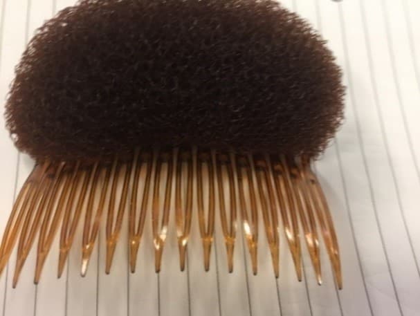 HAIR VOLUME COMB PAD.
THIS IS A HAIR STYLING TOOL TO HELP ADD VOLUME TO YOUR HAIRSTYLE. THE SYNTHETIC FOAM PAD IS USED TO CREATE THE ILLUSION OF THICKER HAIR WHILST THE NON-DETACHABLE PLASTIC COMB HELPS KEEP THE PAD IN PLACE. THIS COMB PAD IS BROWN IN COLOUR.  IT IS PACKAGED IN A SEALED POLYBAG WITH CARDBOARD SUPPORT.