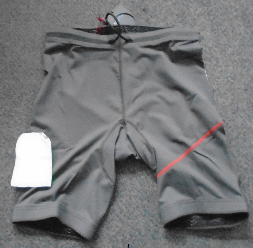 KNITTED UNISEX DECK SHORTS WITH MOST OF THE MATERIAL BEING 88% POLYESTER AND 12% ELASTANE. THE SEAT OF THE SHORTS IS 98% NEOPRENE AND 2% ELASTANE. A CORD GOES ROUND THE WAIST WHICH CAN BE TIED AT THE FRONT. GREY IN COLOUR WITH A LOGO ON THE RIGHT LEG.
