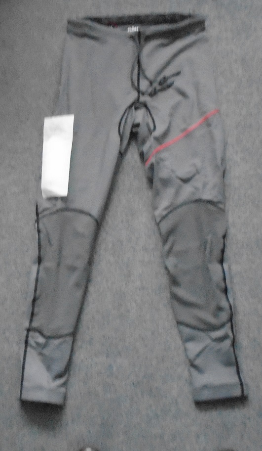 KNITTED UNISEX DECK TROUSERS WITH MOST OF THE MATERIAL BEING 88% POLYESTER AND 12% ELASTANE. THE SEAT OF THE TROUSERS IS 98% NEOPRENE AND 2% ELASTANE. A CORD GOES ROUND THE WAIST WHICH CAN BE TIED AT THE FRONT. GREY IN COLOUR WITH A LOGO ON THE RIGHT LEG.