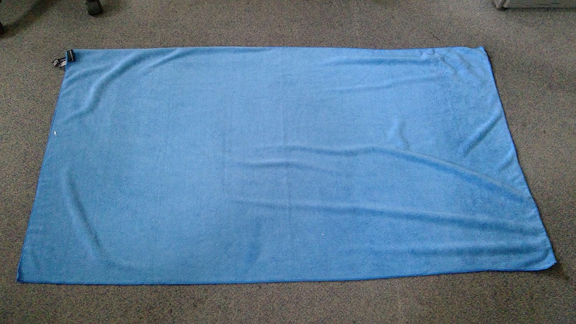 A POLYESTER WOVEN MICROFIBRE TOWEL.  BLUE IN COLOUR.  MADE FROM 80% POLYESTER AND 20% POLYAMIDE.  MEASURES 156CM (APPROXIMATELY) IN LENGTH BY 86CM (APPROXIMATELY) IN WIDTH.  THE TOWEL IS ABSORBENT, QUICK DRYING, THERMAL AND LARGE ENOUGH TO WRAP AROUND THE BODY.  THE TOWEL HAS A LARGE LOOP ON ONE CORNER FOR HANGING.  THE TOWEL COMES IN A PACKAWAY BAG.