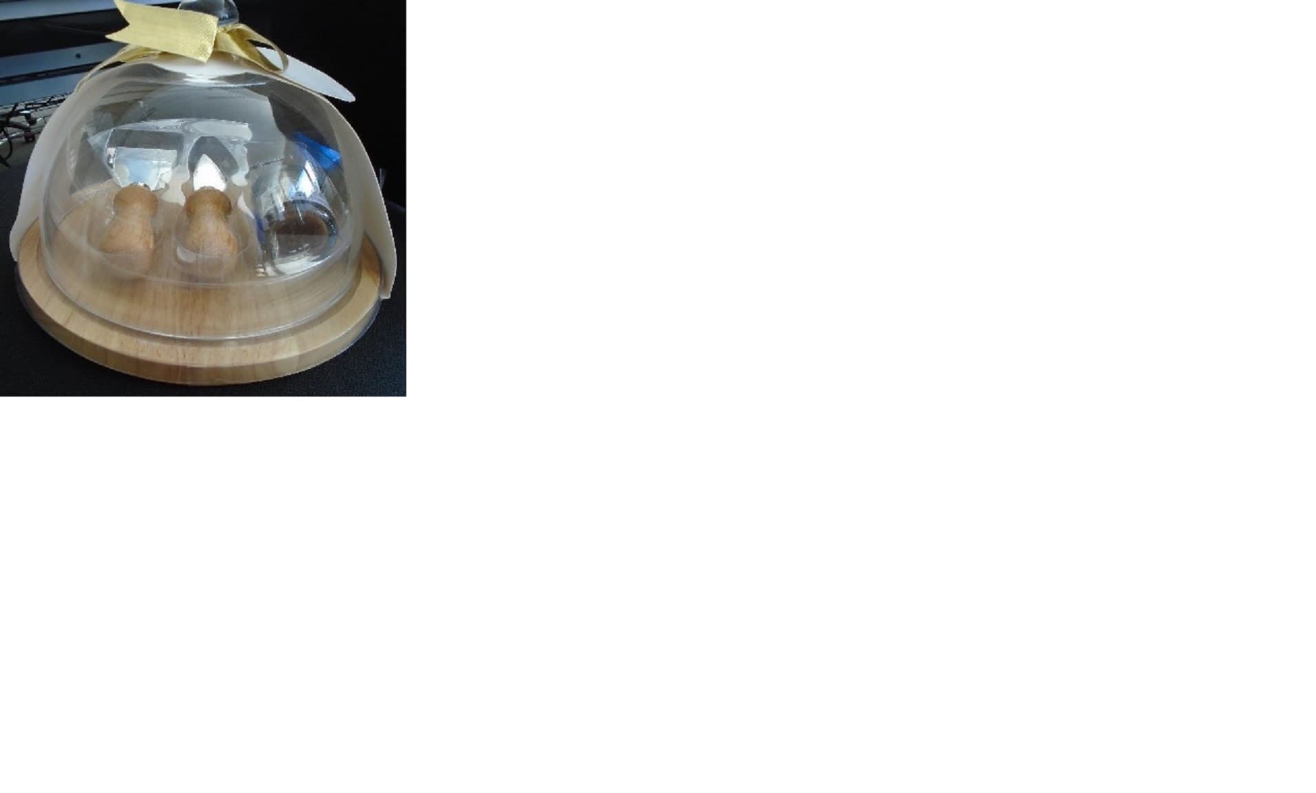 A CIRCULAR CHEESE BOARD SET.CONSISTING OF A RUBBERWOOD BOARD APPROXIMATLEY 24CM IN DIAMETER.THERE ARE TWO BASE METAL  KNIVES WITH WOODEN HANDLES AND A SMALL 38 GRAM JAR OF CARAMELISED ONION CHUTNEY WHICH IS OF NEGLIGIBLE VALUE.THESE ARE SET IN A PLASTIC CASING.THE BOARD, KNIVES AND CHUTNEY  ARE COVERED WITH A GLASS DOME LID.THIS ITEM HAS BEEN PACKAGED USING  A CARDBOARD SLEEVE, A DECORATIVE GOLD RIBBON AND A CARDBOARD GIFT TAG.THIS PRODUCT WILL BE PUT UP FOR RETAIL SALE.