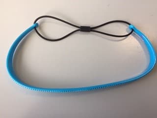 SO CALLED HEADBAND AND HAIRDRESSING AID.  ARTICLE IS MADE FROM FLEXIBLE PLASTIC (67%) AND ELASTIC (33%).  THE PLASTIC HAS TEETH ON THE INSIDE TO HELP HOLD THE BAND IN PLACE.  THE ELASTIC PART (WHICH FORMS THE LOOP) IS RUBBER COVERED IN A KNITTED TEXTILE OUTER.  THE ARTICLE IS USED TO CREATE VARIOUS HAIRSTYLES.