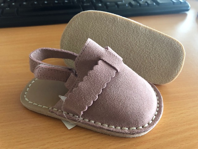 PINK BABY SANDAL WITH AN UPPER, HEEL STRAP AND VAMP MADE OF LEATHER/SUEDE. THE INSOLE AND LINING IS MADE OF LEATHER.  THE OUTER SOLE IS RUBBER.
THE HEEL STRAP ATTACHES TO THE VAMP AND IS VELCRO FASTENED. 
VISIBLE STITCH DETAIL IN A CREAM/WHITE COLOUR ALL AROUND THE SANDAL.
NOT COVERING THE ANKLE.  INSOLE LENGTH OF LESS THAN 24CM.