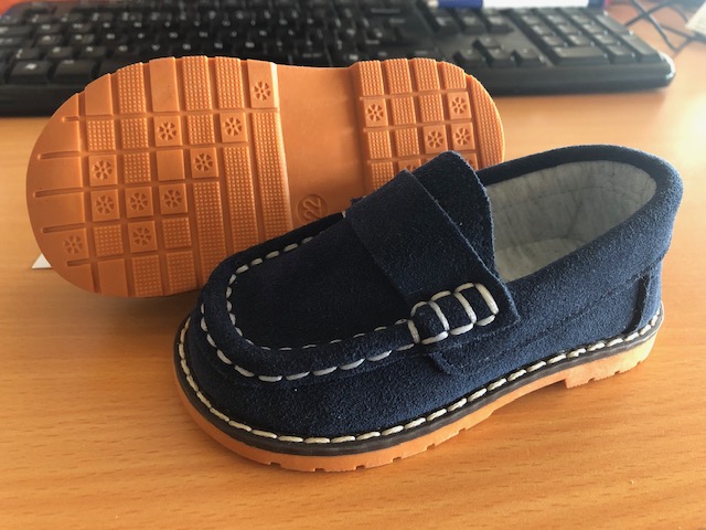 A BABIES SHOE IN A BLUE COLOUR WITH LARGE WHITE STITCH DETAIL TO THE VAMP AND WELT.  UPPER IS MADE OF LEATHER/SUEDE WITH A TEXTILE LINING AND A CUT RUBBER OUTER SOLE.  
NOT COVERING THE ANKLE.  INSOLE LENGTH OF LESS THAN 24CM.