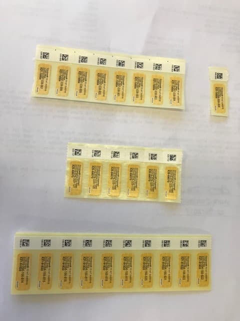 AN OPERATING LICENSE LABEL. THESE ARE PRINTED SELF ADHESIVE PAPER LABELS. THE LABELS ARE PRINTED IN STRIPS, ON A BACKING STRIP AND CAN BE PEELED OFF AND APPLIED TO A POINT OF SALE MACHINE.