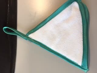 3 IN 1 FACIAL CLEANING CLOTH. IT IS PRIMARILY USED TO CLEAN THE FACIAL AREA,  AS A BEAUTY AID.     

THE CLOTH CONSISTS OF THREE, TRIANGULAR WHITE CLOTHS, BOUND ON EACH EDGE WITH A BIAS OF WOVEN GREEN POLYESTER FABRIC. WITH A LOOP FOR HANGING. THEN STITCHED TOGETHER AT ONE EDGE IN THE FORM OF A BOOK, EACH SIDE MEASURING APPROXIMATELY 14 CM

THE FIRST CLOTH IS AN INTERLOCKED KNITTED NYLON FABRIC ,IT IS OF A ROUGH TEXTURED USED FOR EXFOLIATING THE SKINS SURFACE. 

THE SECOND CLOTH IS A WOVEN POLYESTER PILE FABRIC AND IS SEMI-ROUGH FOR WORKING IN A CLEANSING PREPARATION TO THE SKINS SURFACE.

THE THIRD CLOTH IS A WOVEN PILEPOLYESTER FABRIC AND IS SOFT FOR REMOVING  CLEANSING PRODUCTS AND ANY RESIDUES.

THE CLOTH IS PACKAGED IN A SEALED POLYBAG FOR RETAIL SALE