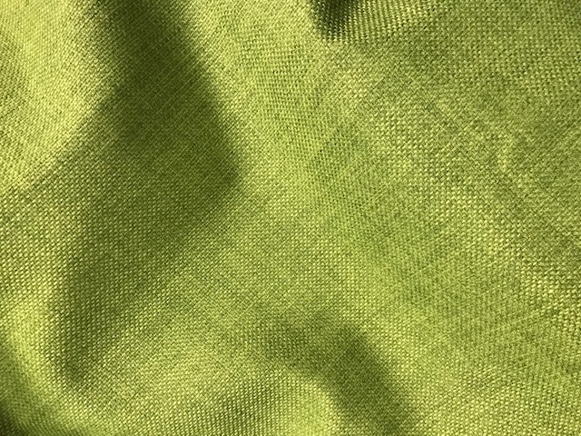 A WOVEN FABRIC. MADE OF 90% TEXTURED FILAMENT POLYESTER YARN, DYED GREEN IN COLOUR. IT IS A LOOSE FABRIC THAT COMES ON A ROLL.