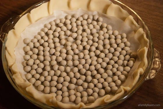 CERAMIC BAKING BEANS. THE ROUND BEANS ARE MADE OF UNGLAZED PORCELAIN AND ARE BEIGE IN COLOUR. THEY ARE USED TO HOLD DOWN GREASEPROOF PAPER WHEN PASTRY IS BAKED BLIND.
THEY ARE PACKAGED IN A ROUND WHITE TIN WITH A SEE THROUGH LID.