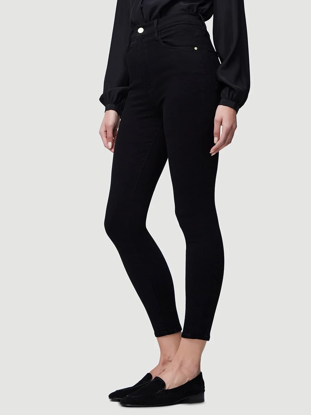 WOVEN MEDIUM WEIGHT TROUSERS (IN A JEANS STYLE) FOR WOMEN MADE FROM 91.5% COTTON, 6% POLYESTER, 2.5% ELASTANE. THE FABRIC IS DYED WITH BOTH WARP AND WEFT YARNS OF THE SAME COLOUR (BLACK) 

WITH RIGHT OVER LEFT ZIP FLY FASTENING, A BUTTON CLOSURE IN THE WAISTBAND. WITH LOOPS SEWN TO THE WAISTBAND DESIGNED TO HOLD A BELT IN PLACE. 

2 REAR PATCH POCKETS, 2 SCOOPED SHAPE FRONT POCKETS AT HIP HEIGHT, METAL STUDS INSERTED TO SECURE THE POCKET EDGE. 1 TICKET POCKET STITCHED ON THE RIGHT FRONT POCKET AT HIP HEIGHT. 

A SLIM FITTING STYLE OF TROUSER WHICH ARE A SHORTER LENGTH  FINISH ABOVE ANKLE WITH FOLDED AND STITCHED HEMS.
